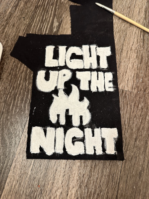 a patch that says light up the night with the silohuette of a city on fire