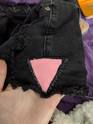 a patch of an upside down pink triangle